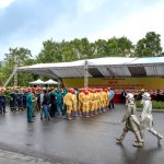 Bombeiros uniformizados reunidos ao ar livre durante uma atividade de segurança e treinamento.