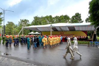 Bombeiros uniformizados reunidos ao ar livre durante uma atividade de segurança e treinamento.