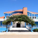Fachada azul de um prédio público brasileiro sob céu claro.