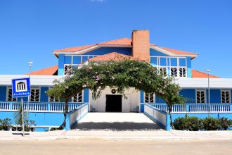 Fachada azul de um prédio público brasileiro sob céu claro.