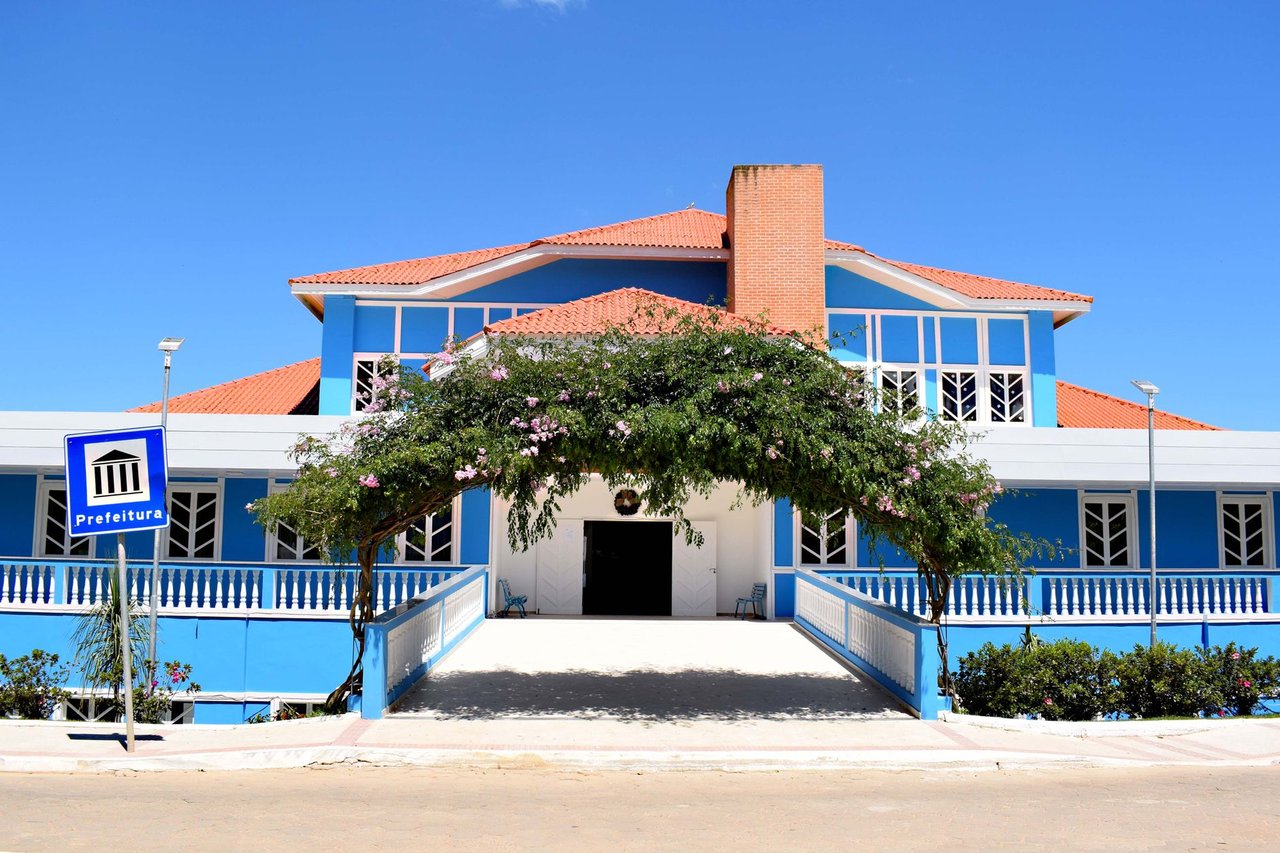 Fachada azul de um prédio público brasileiro sob céu claro.