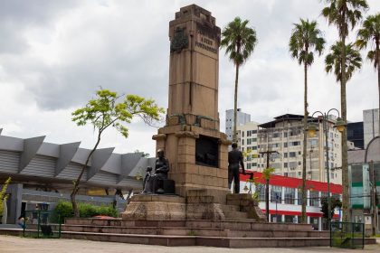 Monumento cercado por palmeiras e edifícios urbanos em Joinville, Santa Catarina
