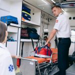 Dois paramédicos organizam suprimentos médicos dentro de uma ambulância para atendimentos de emergência.
