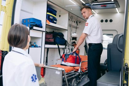 Dois paramédicos organizam suprimentos médicos dentro de uma ambulância para atendimentos de emergência.
